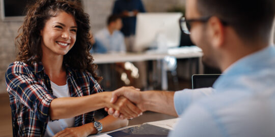 Young SAP Specialist signing contracts and handshake with a manager